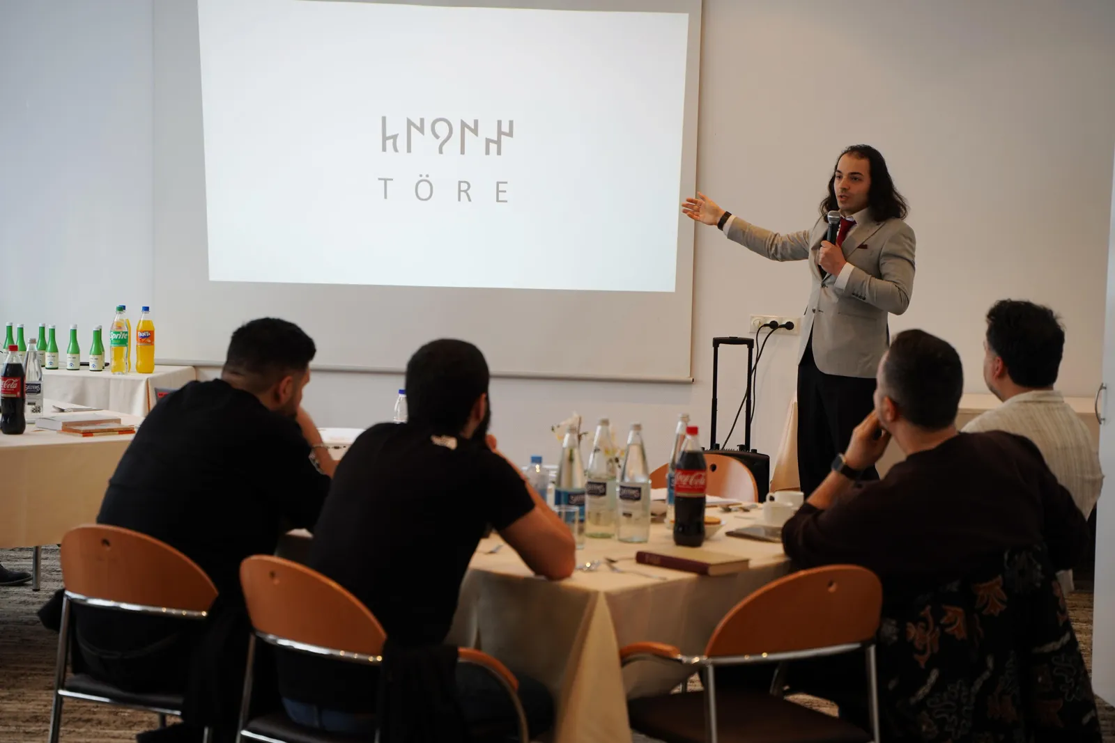 Emre-E. Yavuz spricht in Frankfurt vor einer Folie mit der Aufschrift Töre.